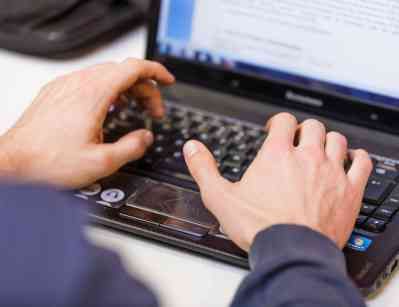 Foto: Hände auf der Tastatur eines Laptops
