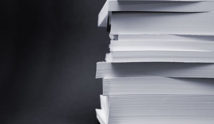 A stack of freshly printed books against a black background.