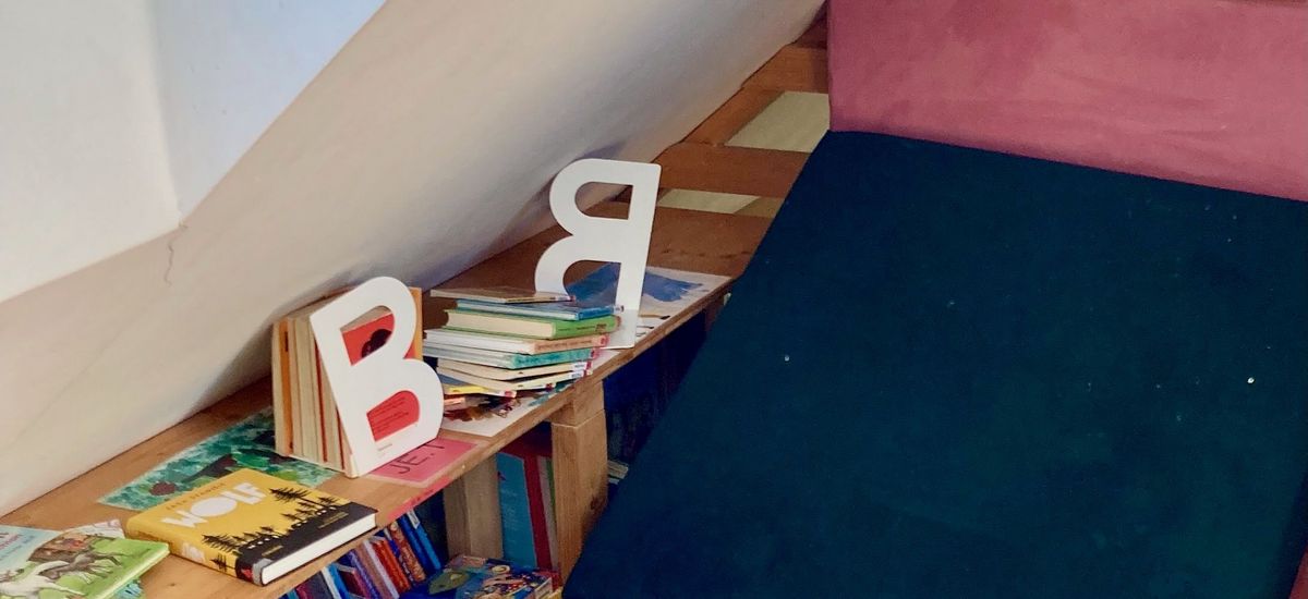Das Bild zeigt einen Lernrückzugsraum in einer Schule. Zu sehen ist eine Dachschräge, Kissen und Mobiliar.