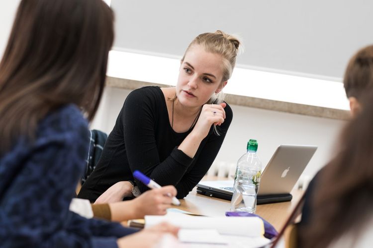 Two students talk about an exercise in a seminar