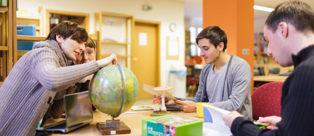 Junge Studierende arbeiten gemeinsam an einem Tisch