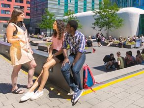 Studierende sitzend und stehend im Gespräch auf dem Campus Augustusplatz