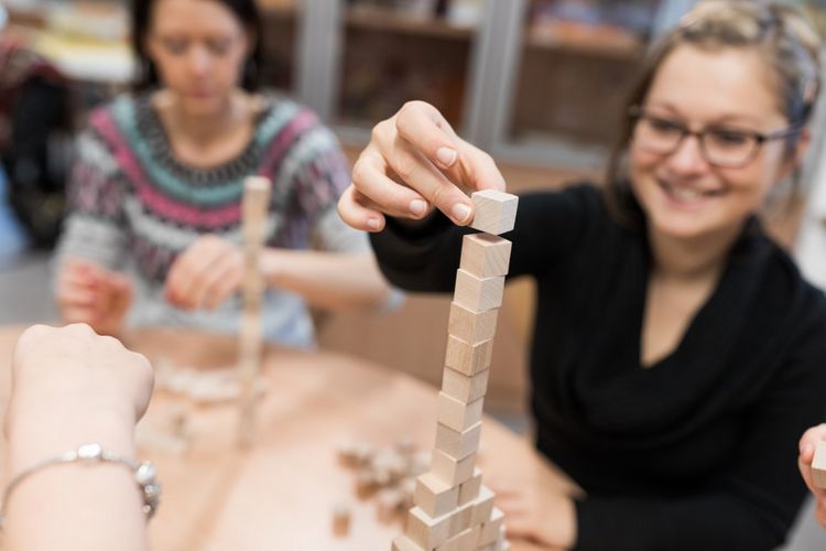 Eine Studentin baut einen Turm aus kleinen Bauklötzen, Foto: Christian Hüller 