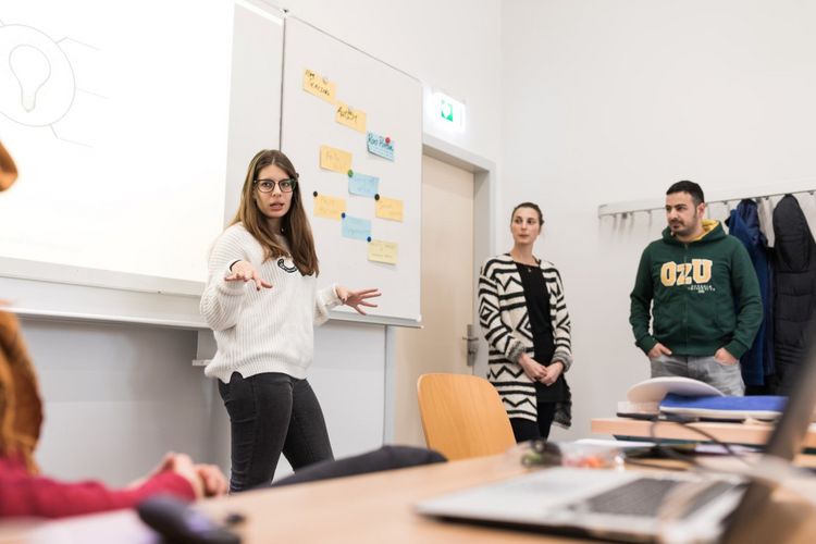 A student explains her topic to a group of students in the seminar