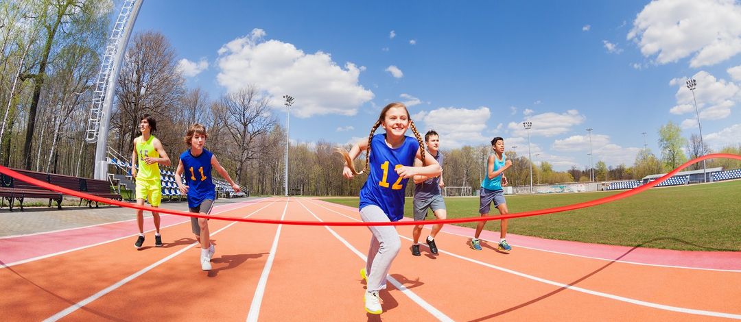 Kinder sprinten auf einer Laufbahn