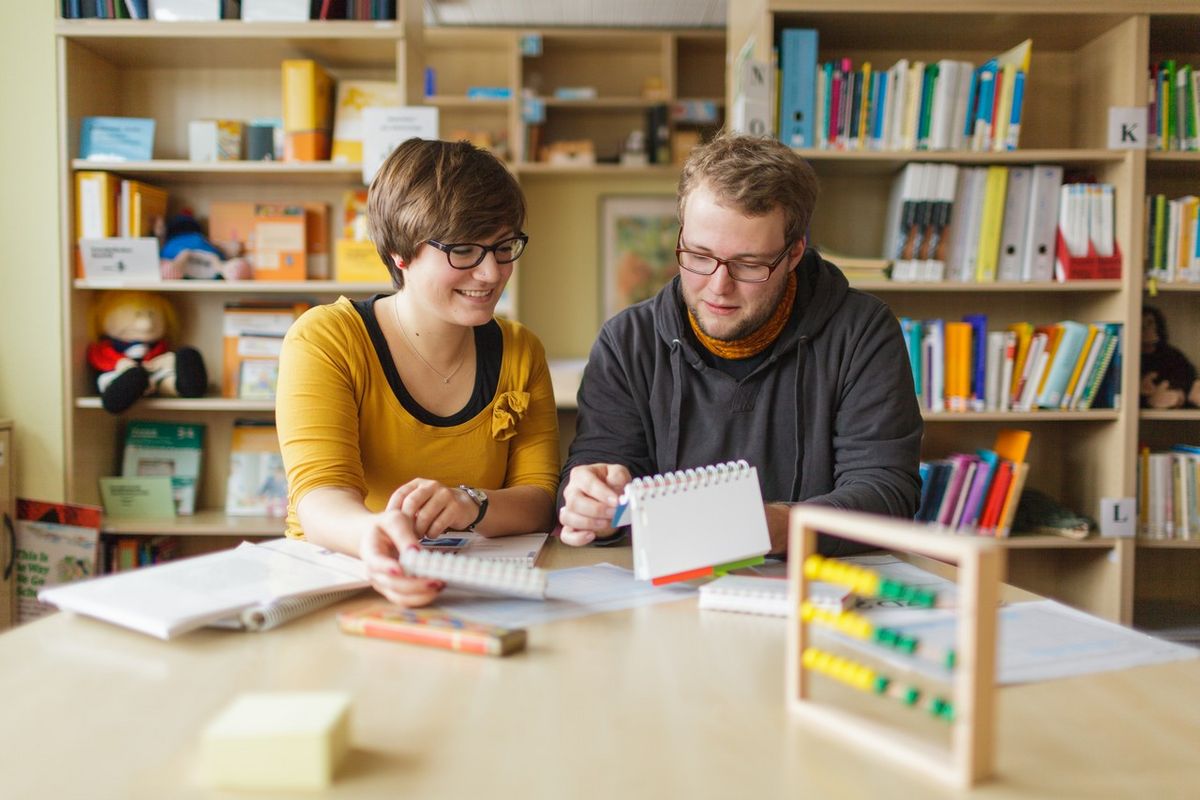 zur Vergrößerungsansicht des Bildes: Zwei Studierende sitzen an einem Tisch und lernen.