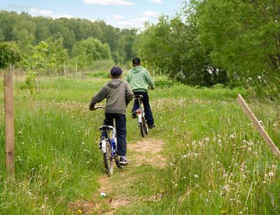 zwei Kinder auf dem Fahrrad in der Landschaft unterwegs