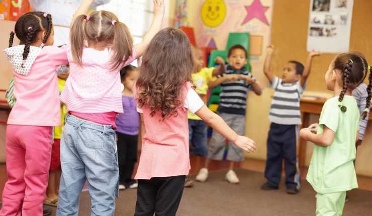 Kinder in einem Kreis in der Kita, die tanzen