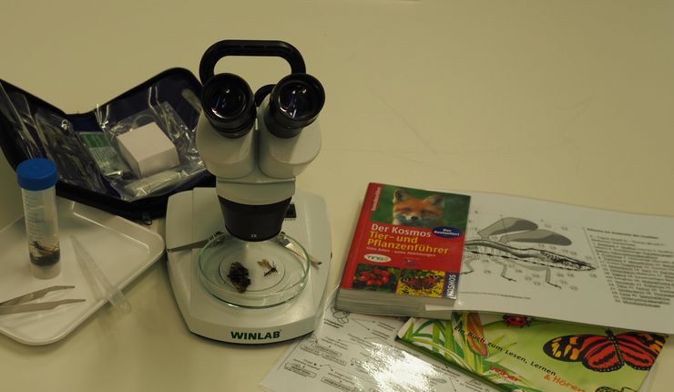 Bild zeigt ein Mikroskop und Arbeitsmaterialien